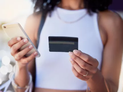 Woman holding library card and phone